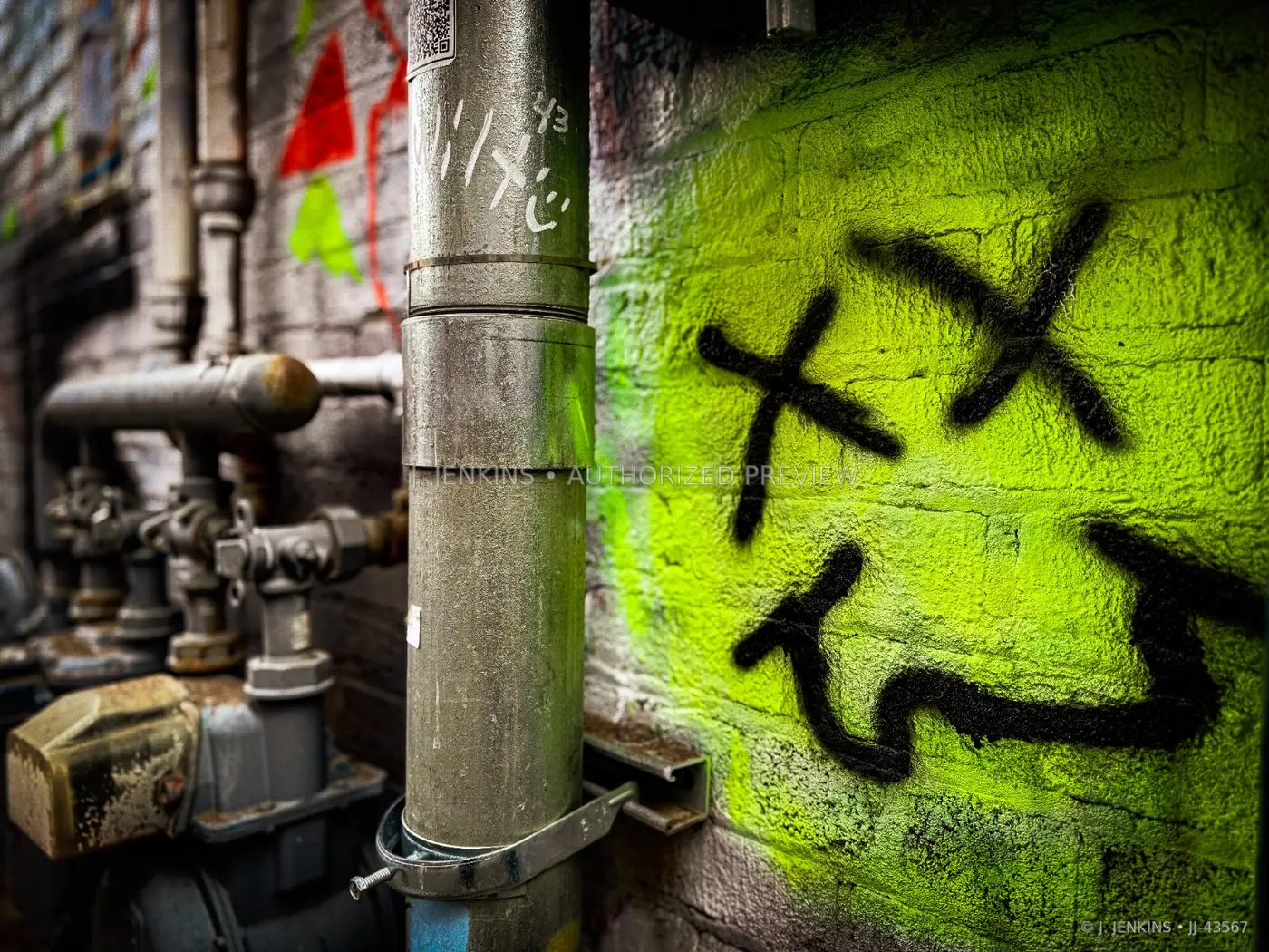 Industrial pipes beside a vivid green painted wall