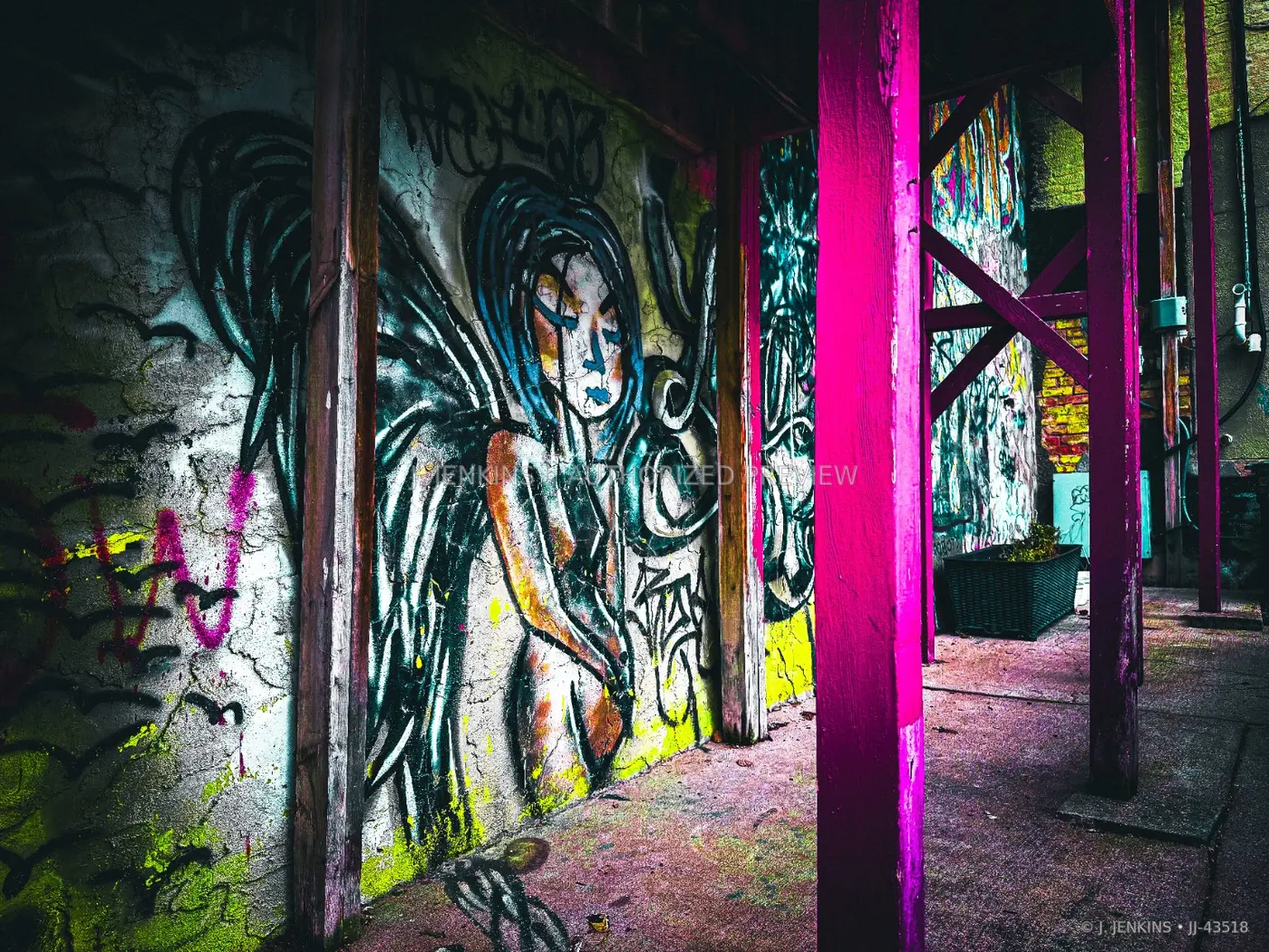Winged figure mural inside a vivid abandoned structure