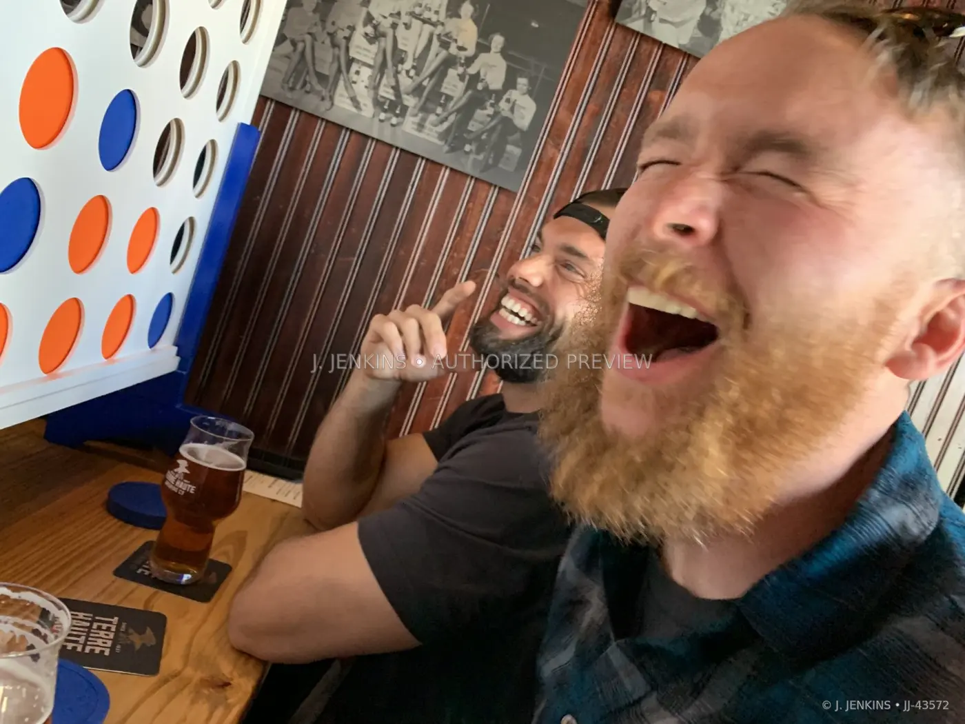 Two friends laughing beside a tabletop game