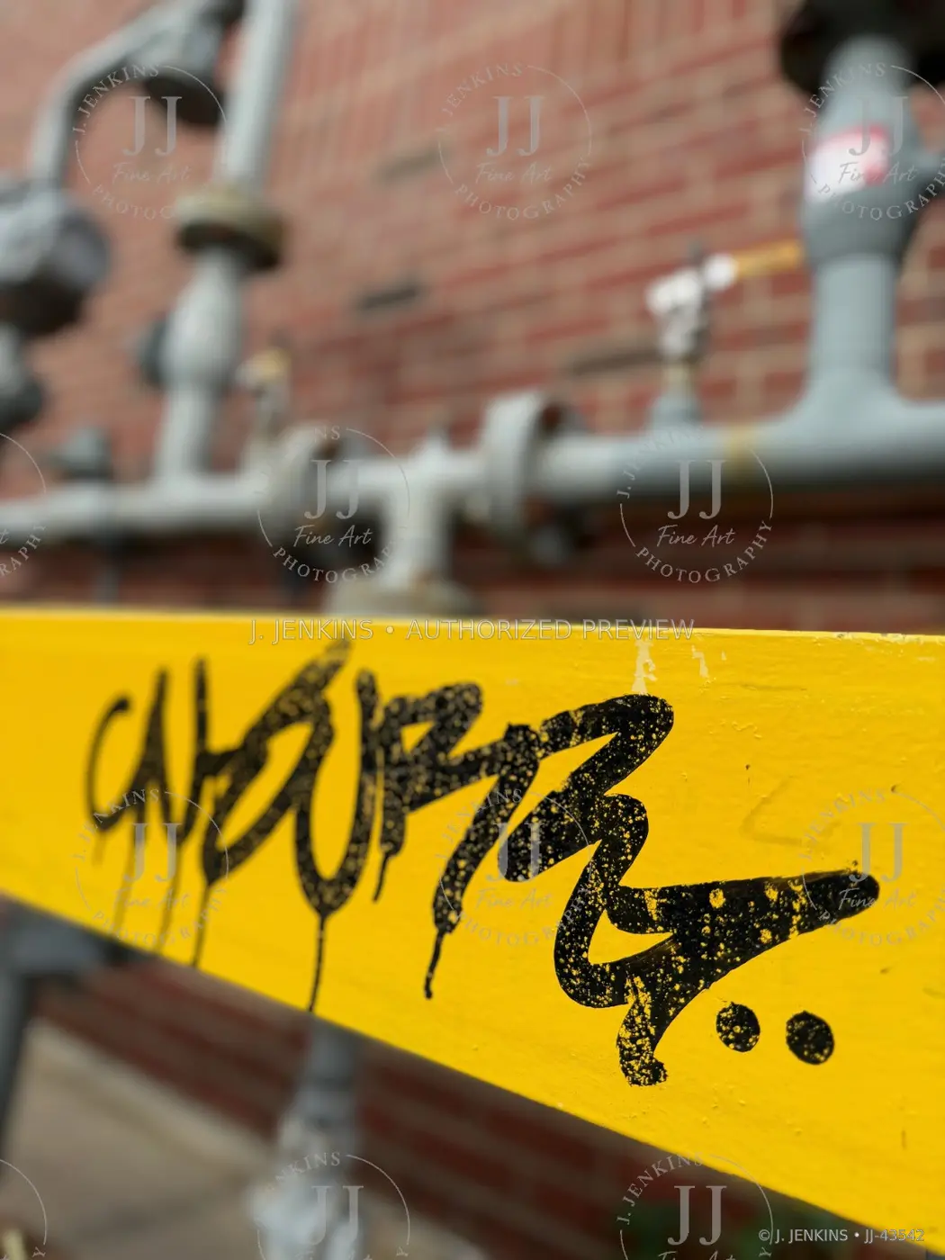 Black tag painted across a yellow industrial rail